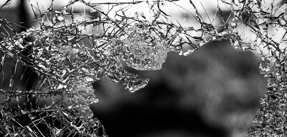 A close up image of a broken glass window